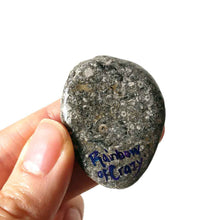 Load image into Gallery viewer, art of a dark gray / black british shorthair cat as an angel, is hand painted on a river rock, and is available as either a keepsake or a pendant necklace, back signed with, rainbowofcrazy