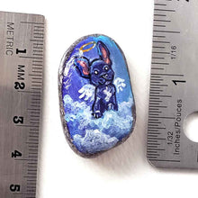 Load image into Gallery viewer, a small beach stone painted with dog art: a black french bulldog as an angel in the clouds. available as a stone keepsake or a pendant necklace