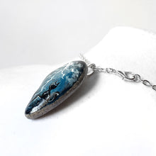 Load image into Gallery viewer, a beach stone necklace, hand painted with a nature scene: a black cat on a cliff, looking out into the night sky, filled with lightning
