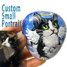 Load image into Gallery viewer, a small stone hand painted with a custom pet portrait of a black and white cat as an angel on the clouds