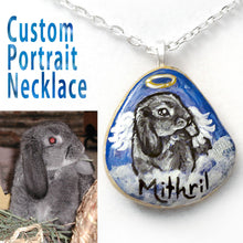 Load image into Gallery viewer, A custom pet portrait painting of a grey mini lop bunny rabbit, painted as an angel, on a small beach rock, crafted into a pendant necklace.