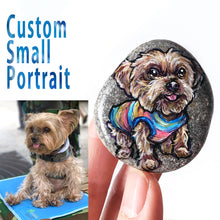 Load image into Gallery viewer, A small beach stone hand painted with the portrait of a yorkshire terrier dog wearing a rainbow shirt