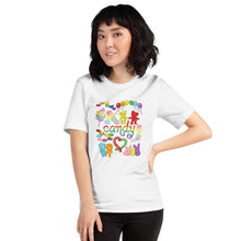 Load image into Gallery viewer, A woman wearing the Candy Lovers Premium Unisex T-shirt in white, which includes a graphic of 10 types of rainbow candy