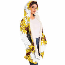 Load image into Gallery viewer, a woman wears a white microfiber fleece cloak (with pockets), printed with sunflower art, with a black cat and white cat peeking out from the flowers