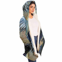Load image into Gallery viewer, a woman wearing a navy blue and orange cloak, featuring art from the Eight of Cups card, from the Animism Tarot: a magpie, with wings spread, flies up into the night sky.