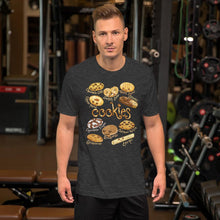 Load image into Gallery viewer, A man wearing the Happy Cookies Premium Unisex T-Shirt in the colour dark grey heather, featuring a graphic of ten different types of cookies with smiling faces