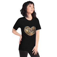 Load image into Gallery viewer, A woman wearing the Otters Love Premium Unisex T-Shirt in the colour heather black, which includes art of two otters forming the shape of a heart.