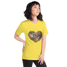 Load image into Gallery viewer, A woman wearing the Otters Love Premium Unisex T-Shirt in the colour yellow, which includes art of two otters forming the shape of a heart.