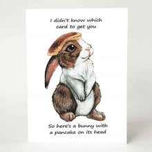 Load image into Gallery viewer, a greeting card, featuring an illustration of a brown and white rabbit with a pancake on its head. front reads, &quot;I didn&#39;t know which card to get you / So here&#39;s a bunny with a pancake on its head&quot;
