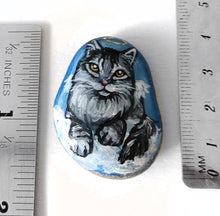 Load image into Gallery viewer, art of a silver gray maine coon cat as an angel, is hand painted on a river rock, and is available as either a keepsake or a pendant necklace
