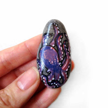 Load image into Gallery viewer, An oval shaped beach stone has been hand painted with a purple and pink octopus and is available as either a keepsake or a pendant necklace
