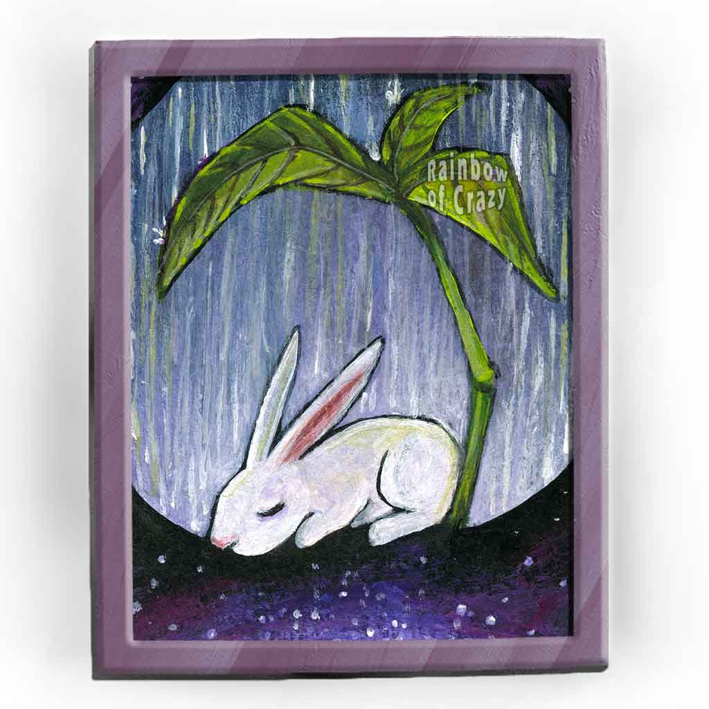 an art print featuring an illustration fo a white rabbit resting under a giant plant, under the rain. with a galaxy of stars below.