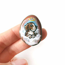 Load image into Gallery viewer, a small beach stone hand painted with the portrait of a beagle as an angel in the clouds, available as a keepsake or pendant necklace
