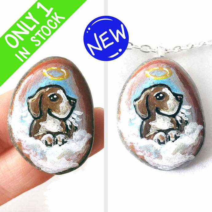 a small beach stone hand painted with the portrait of a beagle as an angel in the clouds, available as a keepsake or pendant necklace