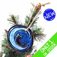 Load image into Gallery viewer, a wood slice ornament, hand painted with the silhouette of a black cat, curled up on a crescent moon, against a dark blue background
