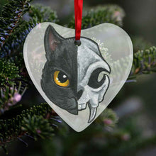 Load image into Gallery viewer, a heart shaped glass ornament, featuring an illustration of a black cat’s portrait. the left side features the cat’s face, while the right side features a stylized cat skull
