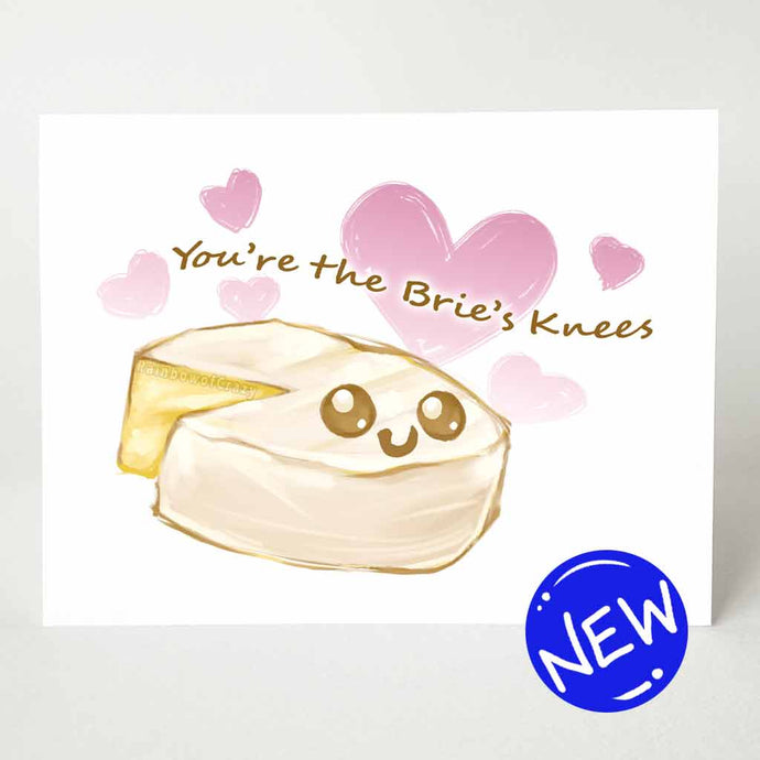 a greeting card with an illustration of a wheel of brie, with one slice missing. it has a smiley face on it. Text says 