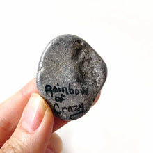 Load image into Gallery viewer, a small beach stone, hand painted with the portrait of a smiling Australian Shepherd dog, as an angel with wings and halo, sitting on fluffy clouds against a blue sky. this piece is available as a stone keepsake or pendant necklace. signed on the back with Rainbow of Crazy
