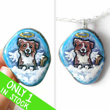 Load image into Gallery viewer, a small beach stone, hand painted with the portrait of a smiling Australian Shepherd dog, as an angel with wings and halo, sitting on fluffy clouds against a blue sky. this piece is available as a stone keepsake or pendant necklace
