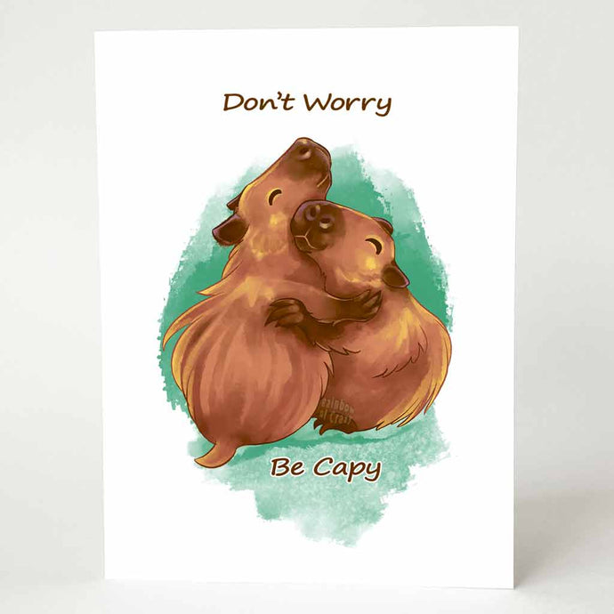 a greeting card with an illustration of two capybaras hugging. the front of the card reads 