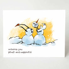 Load image into Gallery viewer, greeting card with an illustration of two snowmen in what looks like a middle of a fight. the right snowman has pulled off the other&#39;s head, while the left snowman (now headless) holds on to the right snowman&#39;s carrot nose. the card reads, &quot;wishing you peace and happiness&quot;
