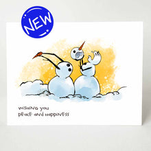 Load image into Gallery viewer, greeting card with an illustration of two snowmen in what looks like a middle of a fight. the right snowman has pulled off the other&#39;s head, while the left snowman (now headless) holds on to the right snowman&#39;s carrot nose. the card reads, &quot;wishing you peace and happiness&quot;
