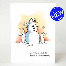 Load image into Gallery viewer, greeting card with an illustration of a smiling snowman with three small white rabbits helping to build it. on the bottom, the card says, &quot;do you want to build a snowman?&quot;
