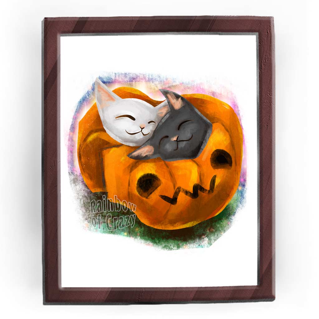 an art print featuring an illustration of a black cat and white cat napping together in a blanket shaped like a jack o'lantern