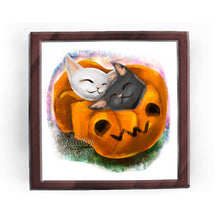 Load image into Gallery viewer, an art print featuring an illustration of a black cat and white cat napping together in a blanket shaped like a jack o&#39;lantern

