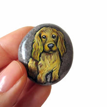 Load image into Gallery viewer, a beach stone hand painted with the portrait of a light brown cocker spaniel dog. this piece is available as a rock keepsake, or pendant necklace
