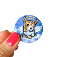 Load image into Gallery viewer, a small lightweight wood disc, hand painted with a portrait of a corgi at an angel in the clouds, against a blue sky, available as a keepsake or a pendant necklace
