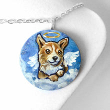 Load image into Gallery viewer, a small lightweight wood disc, hand painted with a portrait of a corgi at an angel in the clouds, against a blue sky, available as a keepsake or a pendant necklace
