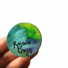 Load image into Gallery viewer, a lightweight wood disc, hand painted with the portrait of a dachshund, as an angel, sitting on fluffy clouds against a green and blue sky. available as a keepsake or pendant necklace, signed on the back with Rainbowofcrazy
