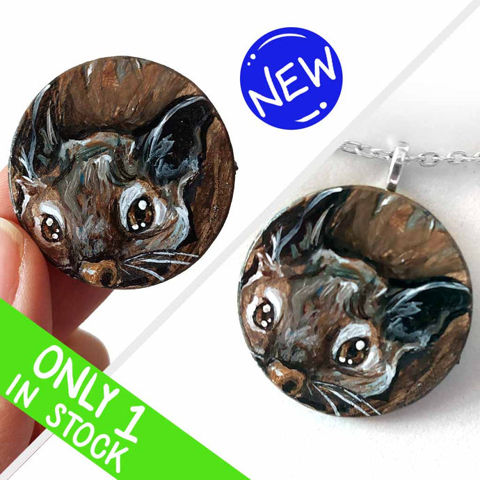 a small wood disc, featuring a painting of a little degu. this painting is available as a pendant or wood keepsake.
