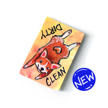 Load image into Gallery viewer, yellow and orange wood magnet, hand painted with a corgi with a tail in a heart shape, tongue out, doing a sploot. near the top of the dog&#39;s head is the word CLEAN. written upside down next to the dog&#39;s butt is the word DIRTY
