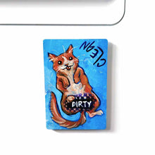 Load image into Gallery viewer, blue wood magnet, hand painted with an orange cat with its tongue out. near the top of the cat&#39;s head is the word CLEAN. a black bar covers the cat&#39;s crotch and says the word DIRTY. around the bar, the cat&#39;s body is pixelated
