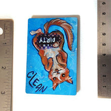 Load image into Gallery viewer, blue wood magnet, hand painted with an orange cat with its tongue out. near the top of the cat&#39;s head is the word CLEAN. a black bar covers the cat&#39;s crotch and says the word DIRTY. around the bar, the cat&#39;s body is pixelated
