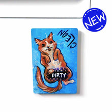 Load image into Gallery viewer, blue wood magnet, hand painted with an orange cat with its tongue out. near the top of the cat&#39;s head is the word CLEAN. a black bar covers the cat&#39;s crotch and says the word DIRTY. around the bar, the cat&#39;s body is pixelated
