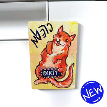 Load image into Gallery viewer, yellow wood magnet, hand painted with an orange cat with its tongue out. near the top of the cat&#39;s head is the word CLEAN. a black bar covers the cat&#39;s crotch and says the word DIRTY. around the bar, the cat&#39;s body is pixelated
