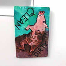 Load image into Gallery viewer, wood magnet on a dishwasher, hand painted with a pig with the word CLEAN (upside down) next to its face at the top. the second half of the pig is muddy, and written next to its body, DIRTY.
