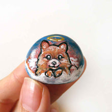 Load image into Gallery viewer, a small stone, hand painted with a portrait of a Pomeranian dog as an angel in the clouds, available as a keepsake stone or pendant necklace 
