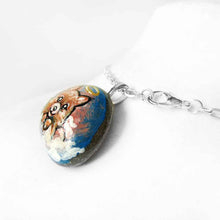 Load image into Gallery viewer, a small stone, hand painted with a portrait of a Pomeranian dog as an angel in the clouds, available as a keepsake stone or pendant necklace 
