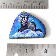 Load image into Gallery viewer, a small beach stone, painted with a portrait of a ferret as an angel in the clouds
