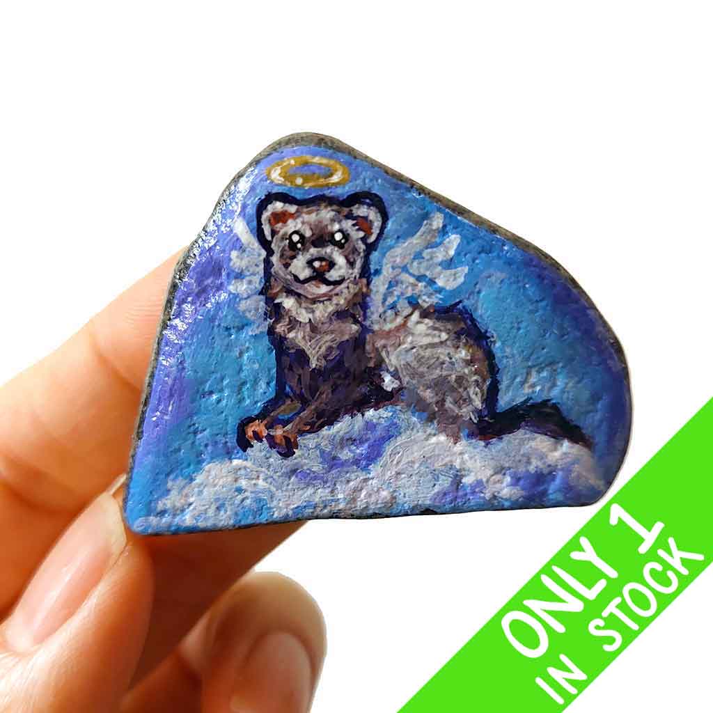 a small beach stone, painted with a portrait of a ferret as an angel in the clouds