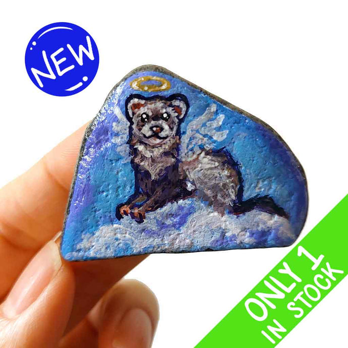 a small beach stone, painted with a portrait of a ferret as an angel in the clouds