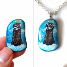 Load image into Gallery viewer, a small beach stone, painted with a smiling ferret angel, with halo and wings, on top of clouds, against a blue sky. available as a keepsake, magnet or pendant necklace
