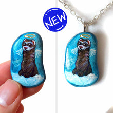 Load image into Gallery viewer, a small beach stone, painted with a smiling ferret angel, with halo and wings, on top of clouds, against a blue sky. available as a keepsake, magnet or pendant necklace
