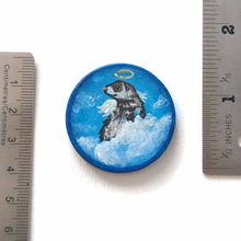 Load image into Gallery viewer, a wood circle keepsake, painted with a portrait of a ferret as an angel, with halo, and wings, sitting on clouds agains a blue background. available as a mini painting or pendant necklace
