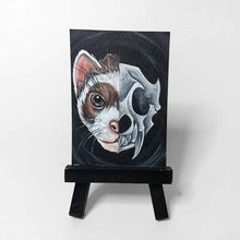 Load image into Gallery viewer, an aceo sized painting split into two sides. the left side shows half of a ferret&#39;s face. the right side shows an eerie ferret&#39;s skull. the painting sits on a tiny black easel
