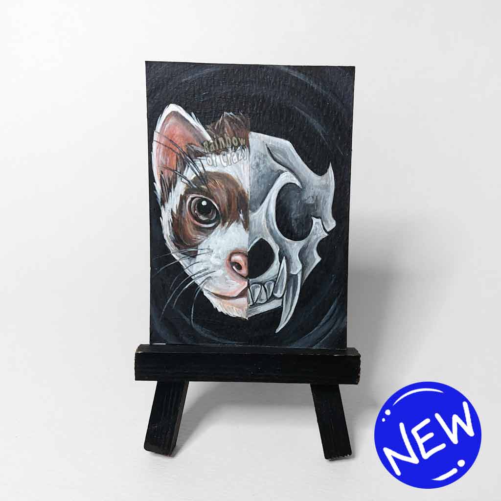 an aceo sized painting split into two sides. the left side shows half of a ferret's face. the right side shows an eerie ferret's skull. the painting sits on a tiny black easel